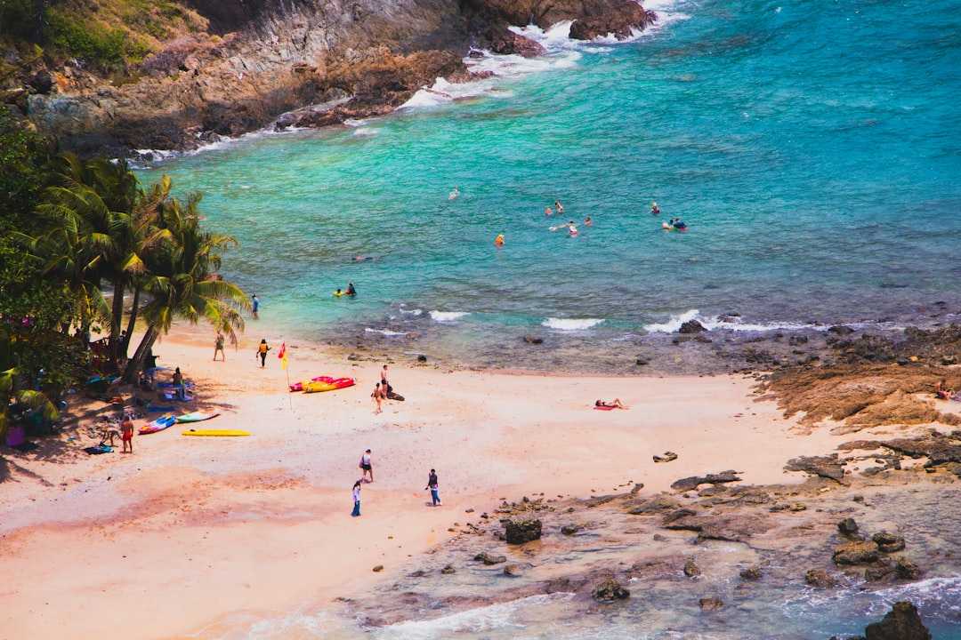 Tropical beach with people swimming and sunbathing.
